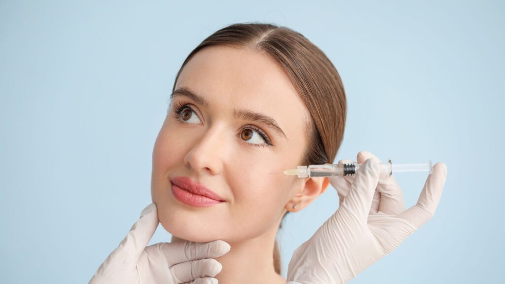 Professional aesthetician administering Radiesse dermal filler injection to a woman’s cheek at PureMargins Aesthetic Clinic in Chicago.